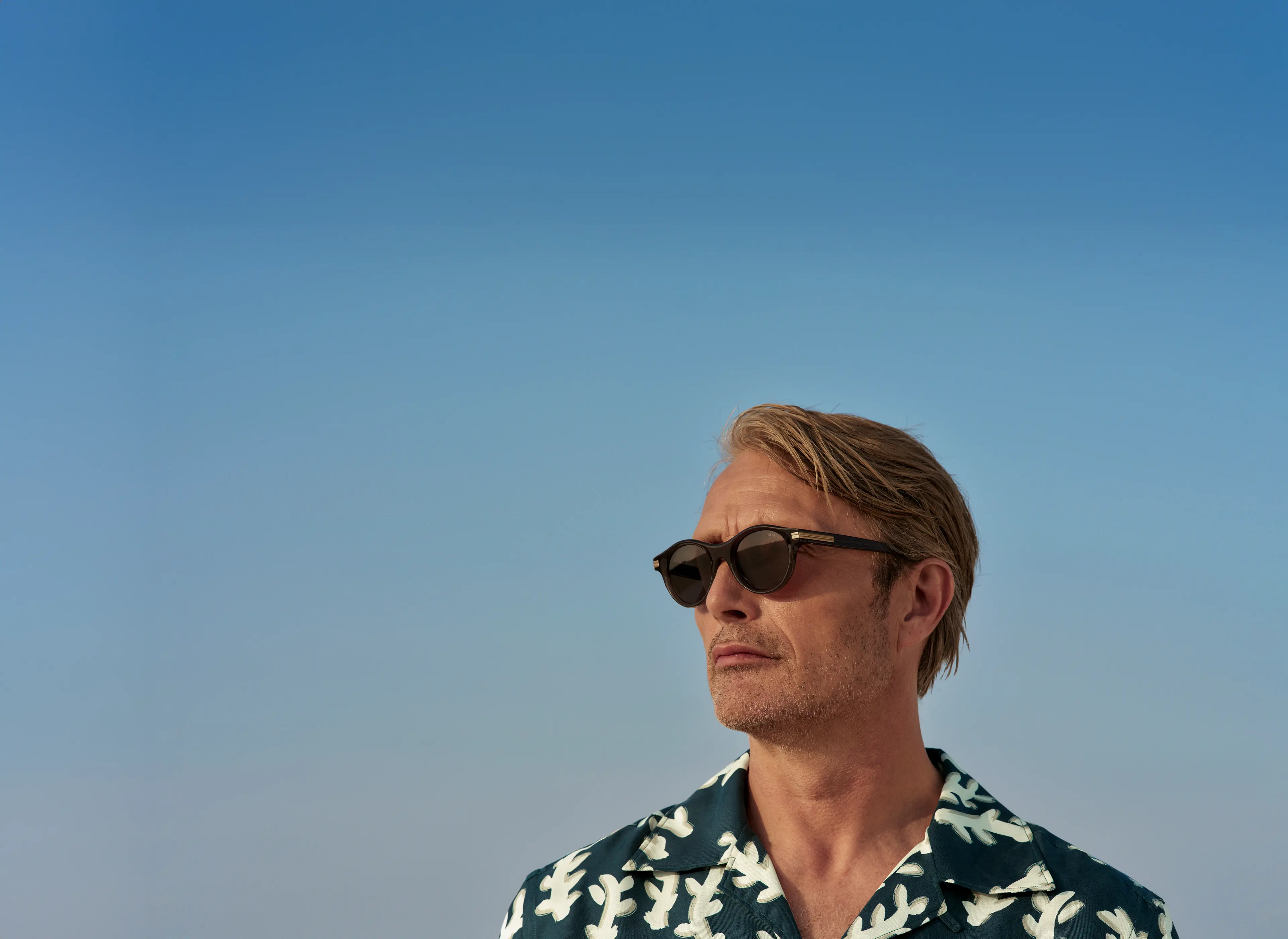 Mads Mikkelsen 佩戴乙酸纤维太阳镜,身穿 ZEGNA(杰尼亚)2025 春夏系列衬衫。